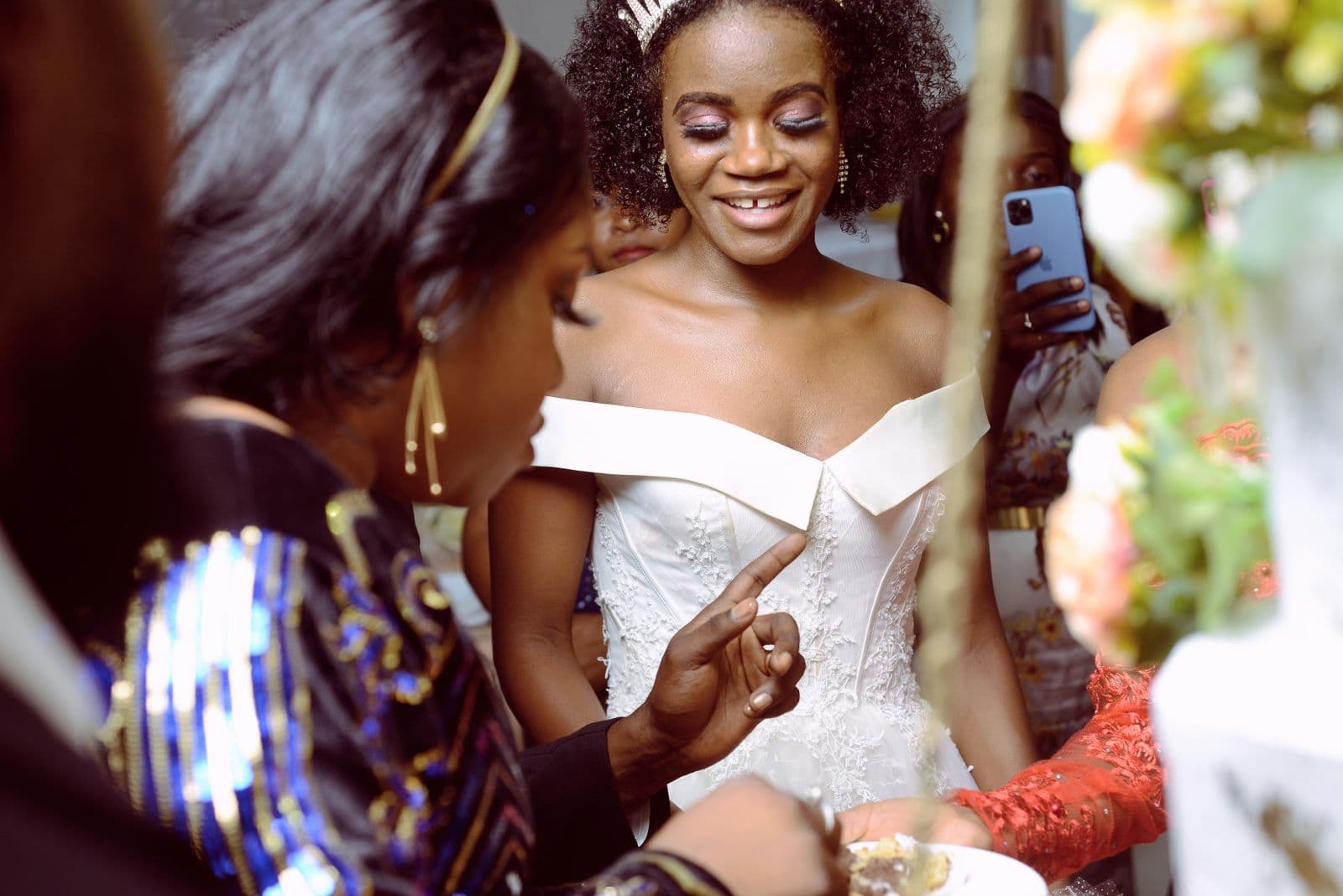 A wedding guest holding up a phone to photograph the bride
