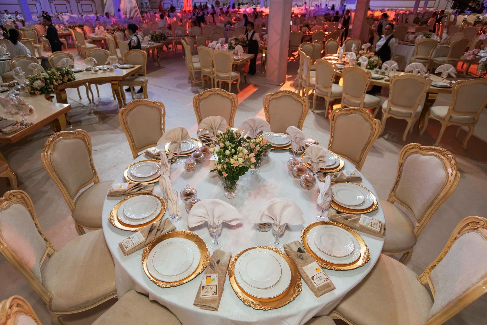 An elegant wedding banquet hall set with many place settings