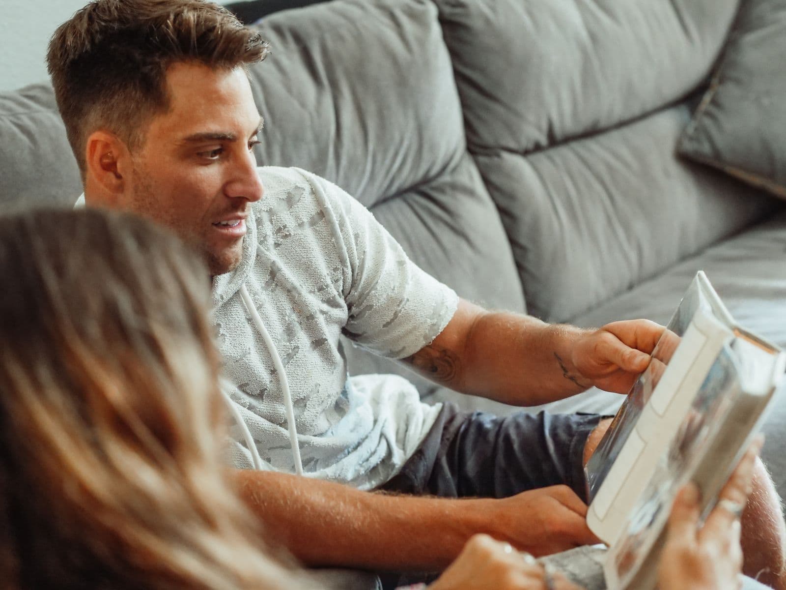 A couple relaxing at home looking through a wedding photo book