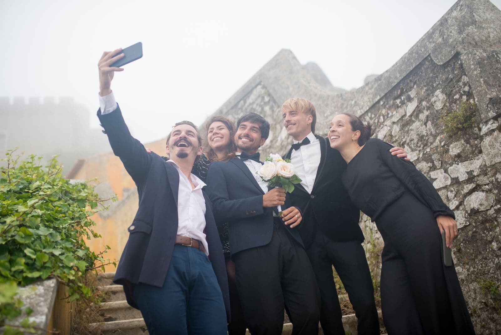 A group of wedding guests taking a selfie together on a phone