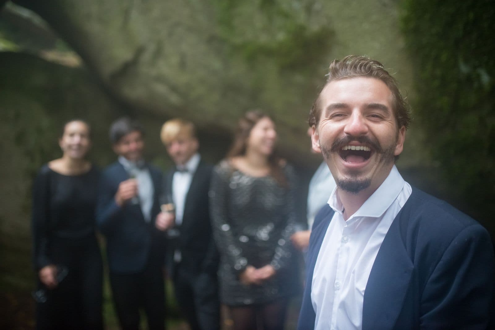 A wedding guest laughing during an evening celebration