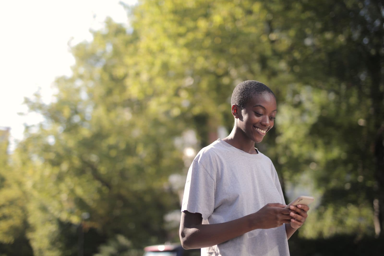 A woman smiling as she looks at photos on her phone