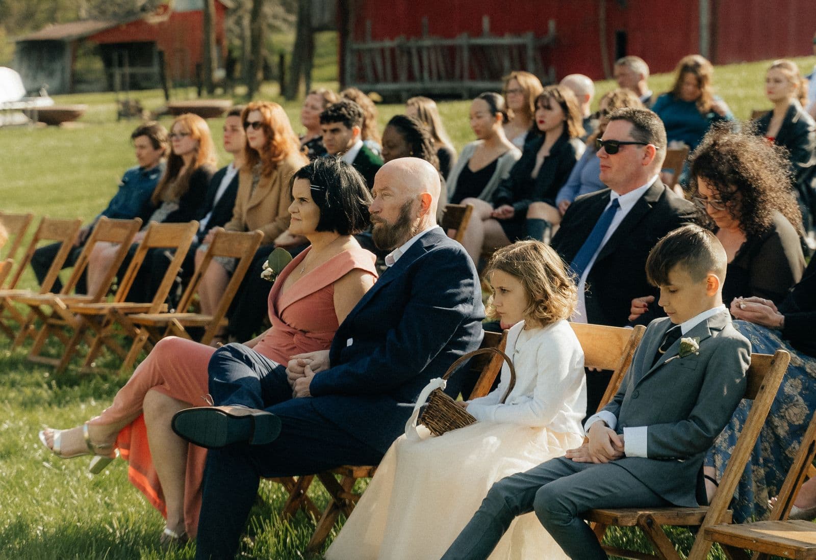 Guests seated watching an outdoor barn wedding ceremony