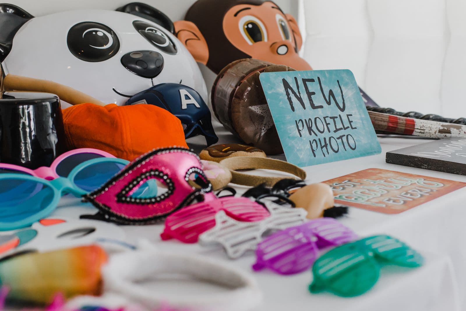 A table of colorful photo booth props including masks and novelty glasses