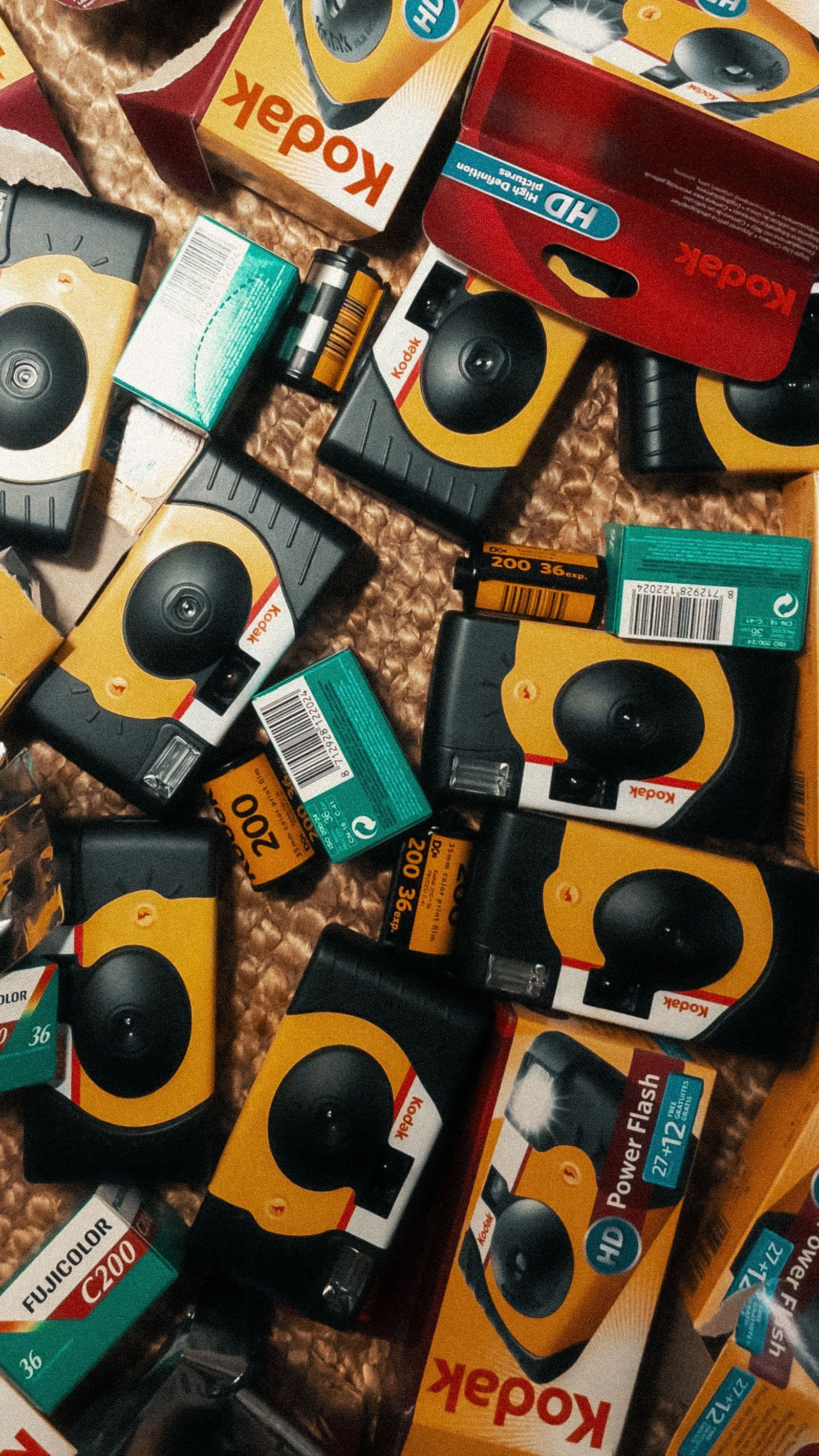 A pile of disposable film cameras and film boxes