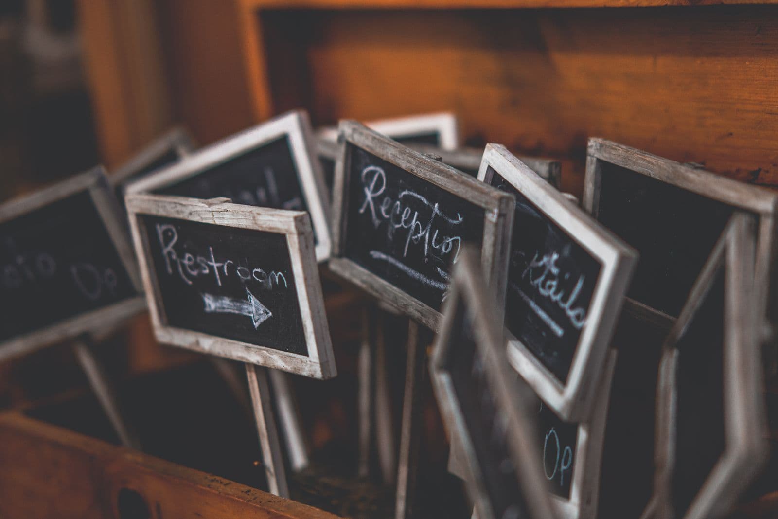 A row of small rustic chalkboard wedding signs lettered by hand