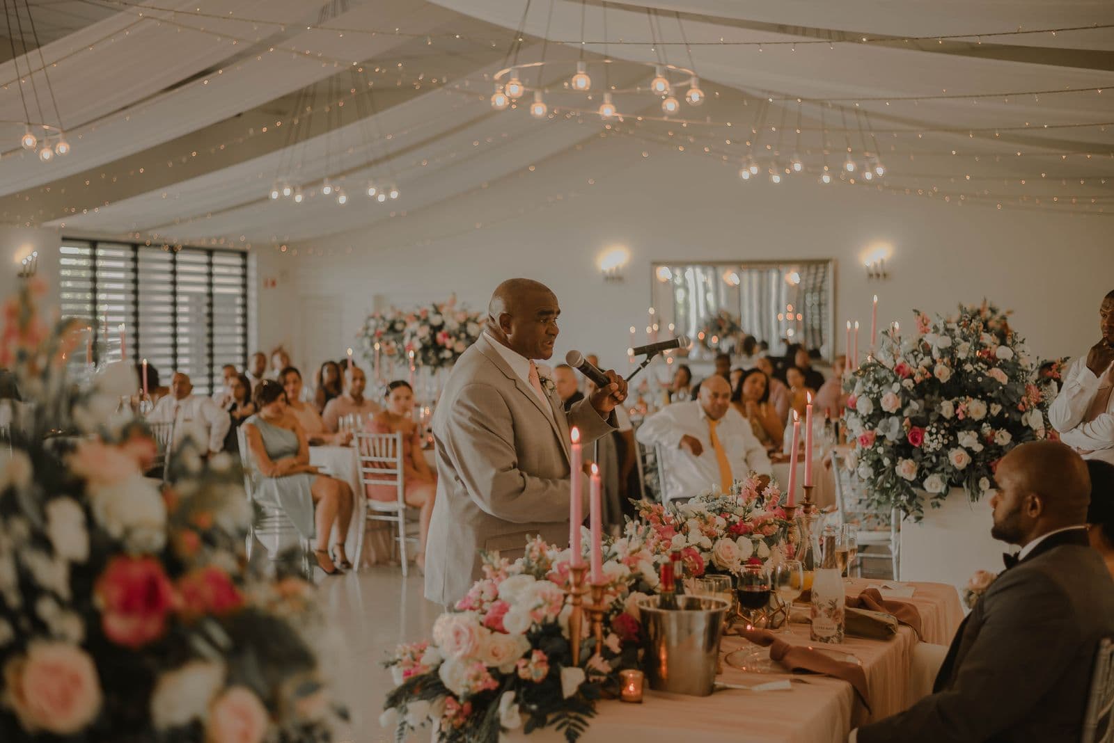 Guests watching at an elegant wedding reception under string lights
